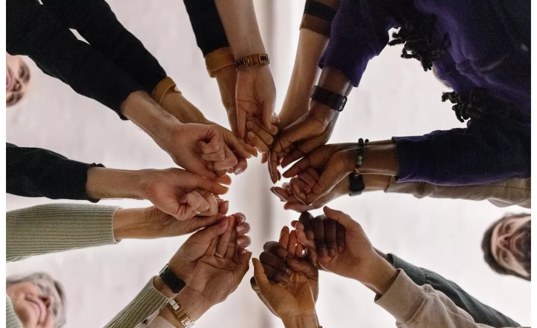 Un gruppo di persone in cerchio che si dà la mano