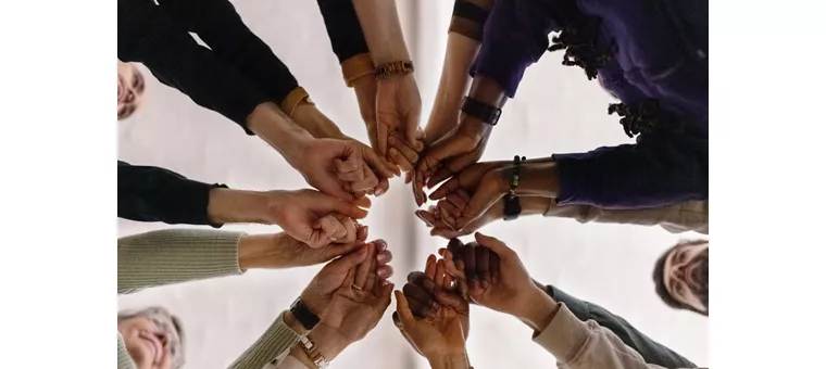 Un gruppo di persone in cerchio che si dà la mano