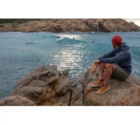 Niño en las rocas frente al mar