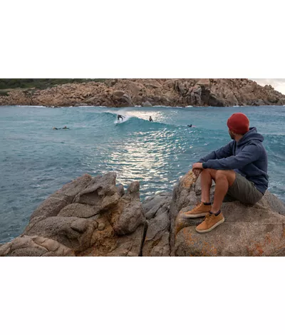 Ragazzo sugli scogli di fronte al mare