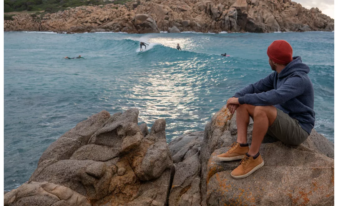 Ragazzo sugli scogli di fronte al mare