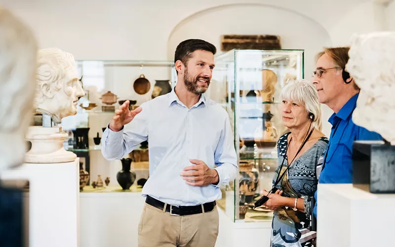 Guía turístico y visitantes en un museo