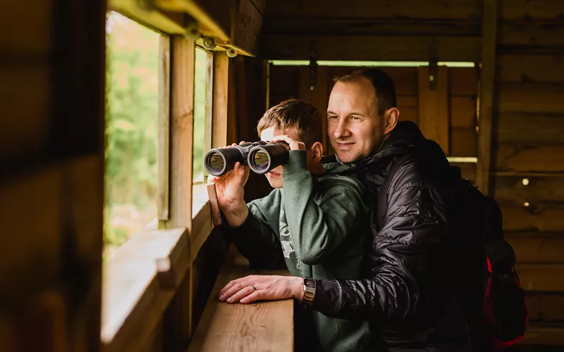 Boy and father birdwatching in Italy