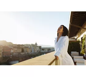 A woman looking out onto a balcony in Florence