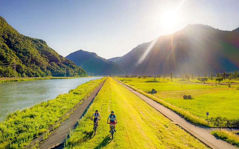 Dos ciclistas en la ribera del río Adda en Lombardía