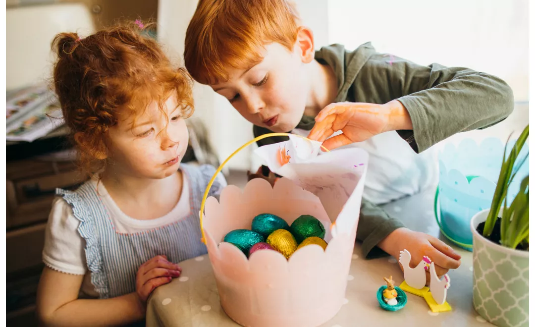 Two children with a basket of Easter eggs