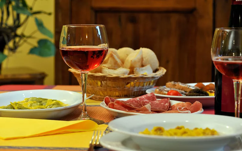 tavola con prodotti tipici e bicchieri di lambrusco