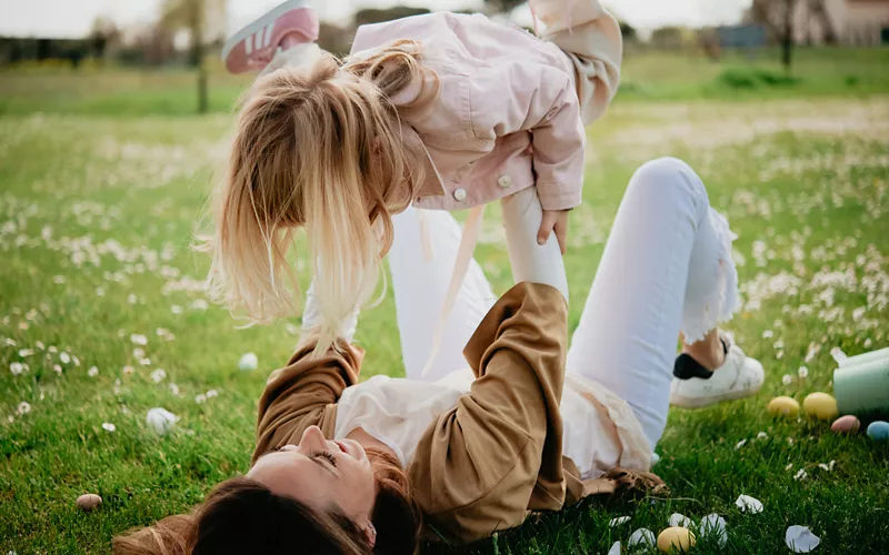 A woman and a child playing in the park