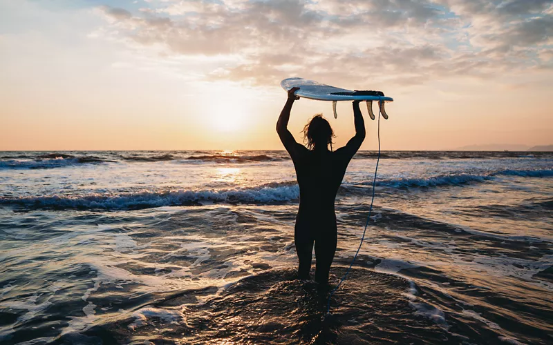 Surfista al mare al tramonto