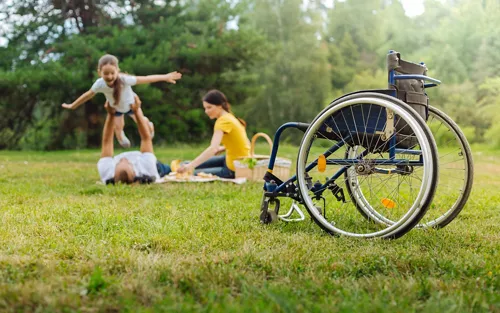 Una familia en el parque y una silla de ruedas