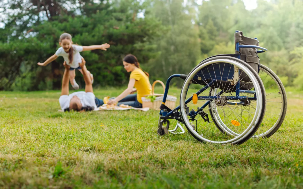Una famiglia al parco e una sedia a rotelle