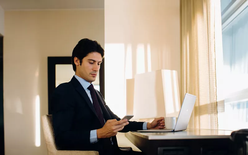 Uomo che lavora al computer in hotel