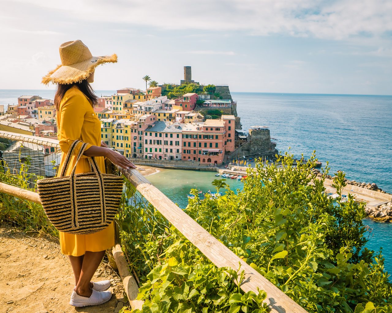 View of Vernazza one of Cinque Terre in the province of La Spezia, Italy, happy young couple picnic in the mountain with a look over the ocean Italy
