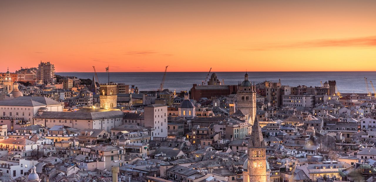 Genoa, Genova, Italy: Amazing sunset panoramic aerial view of Genoa old town historic centre (San Lorenzo Cathedral, duomo, Palazzo Ducale, Torre Grimaldina), sea and port at dusk, by night. Panorama