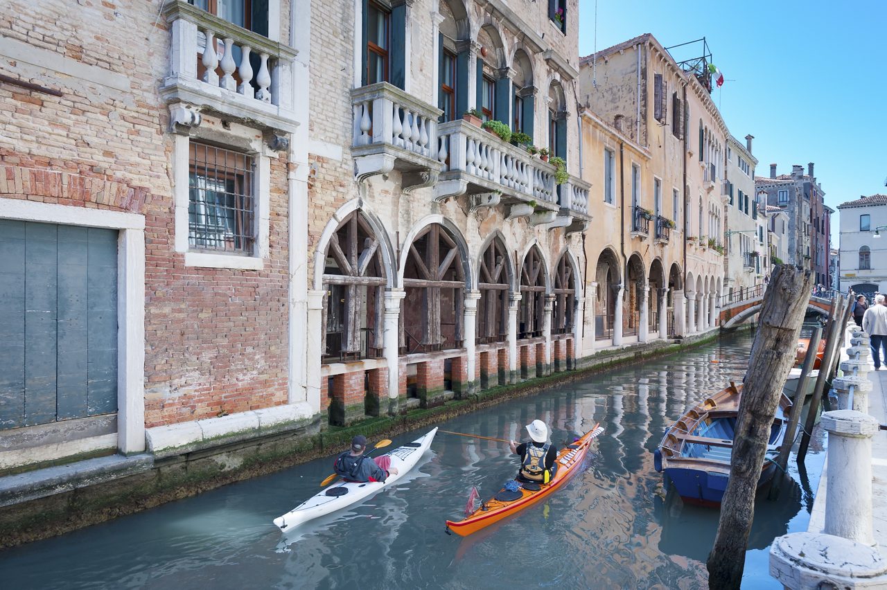 traveler kayaking in canal in Venice, Italy