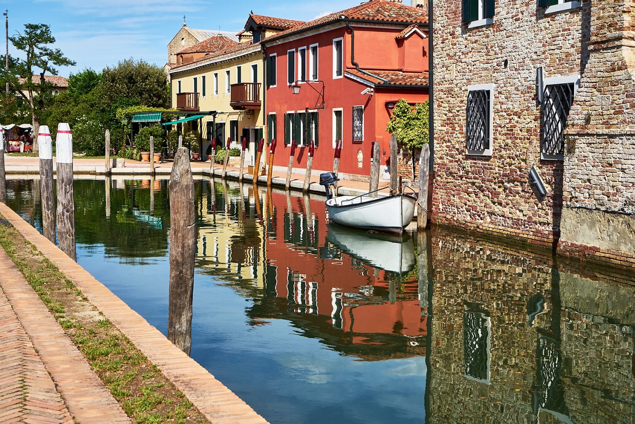 Torcello, Venice. Colorful houses on Torcello island,  canal and boats. Summer, Italy