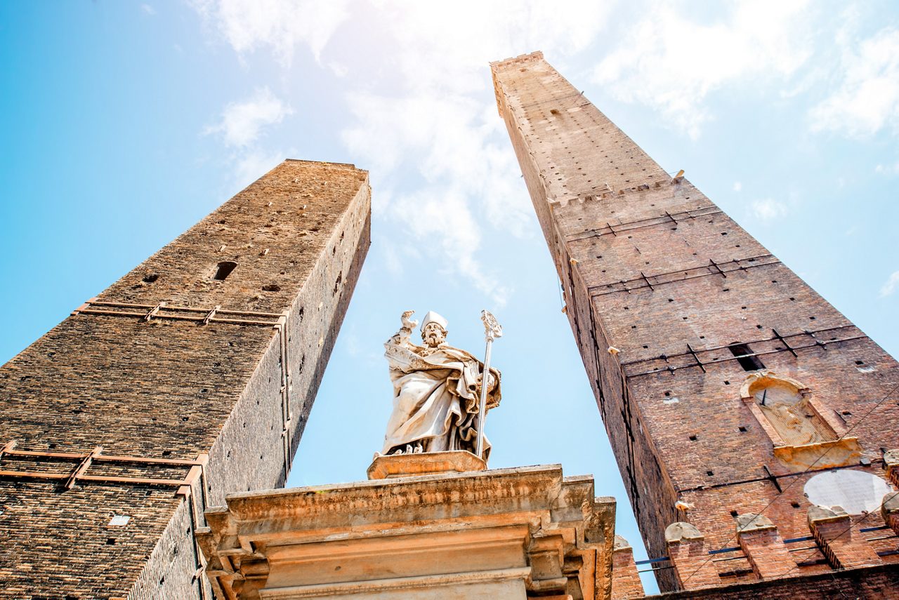 Two famous leaning towers and Petronius statue in Bologna city. Bologna's two leaning towers are the city's main symbol