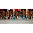 Foto delle gambe di maratoneti che corrono su strada.