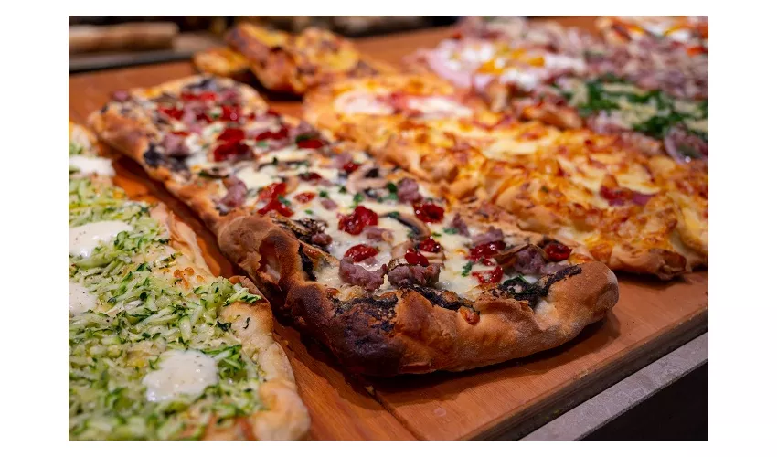 Fresh baked focaccia or pala romana pizza with vegetables and cheese in bakery in Parma, Emilia Romania, Italy close up