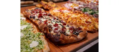 Fresh baked focaccia or pala romana pizza with vegetables and cheese in bakery in Parma, Emilia Romania, Italy close up