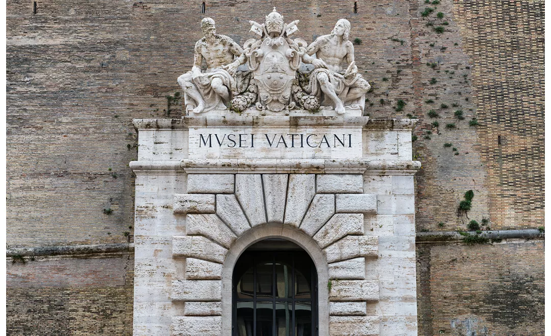 L’ingresso storico dei Musei Vaticani, oggi uscita, nelle cinquecentesche mura vaticane: le statue che lo sormontano raffigurano Michelangelo e Raffaello.