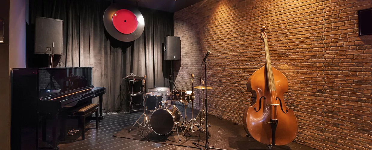 Modern jazz bar interior design, stage with black piano and cello