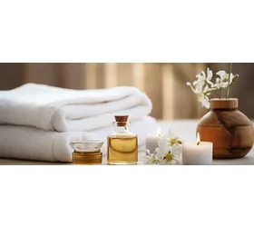 Spa decoration with candle, daisies , white flowers and a bottle with massage oil, beauty wellness centre. Spa product are placed in luxury spa resort room. 